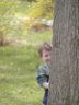 Robert peeks from behind a tree